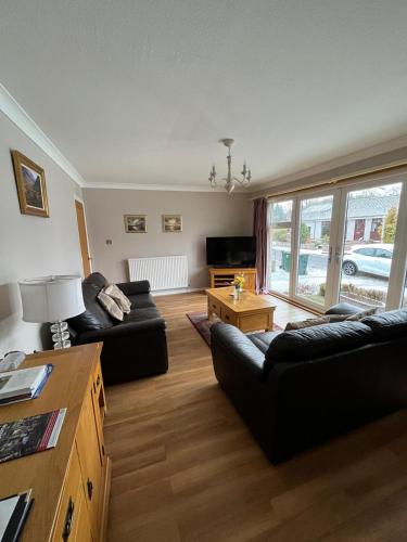 a living room with two couches and a table at Isla Cottage in Blairgowrie