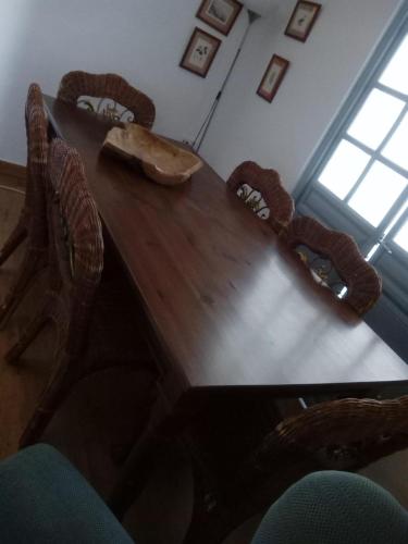 a dining room table with chairs and a wooden table with a bowl at Casa de Comedias in Almagro