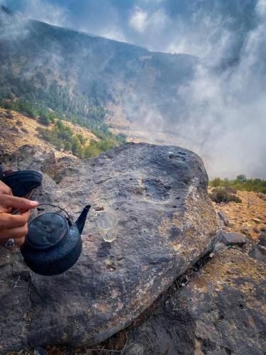 a person holding a tea pot on top of a rock at Dana Star lodge in Dana