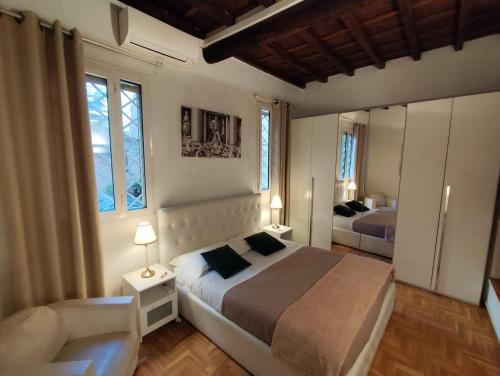 ローマにあるCozy Navona Apartmentのベッドと椅子と2つの窓がある寝室