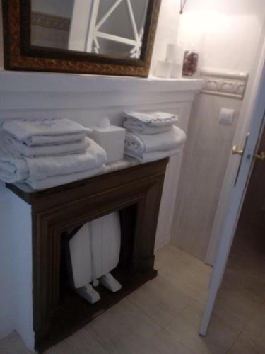 a bathroom with a table with towels and a mirror at Casa de Comedias in Almagro