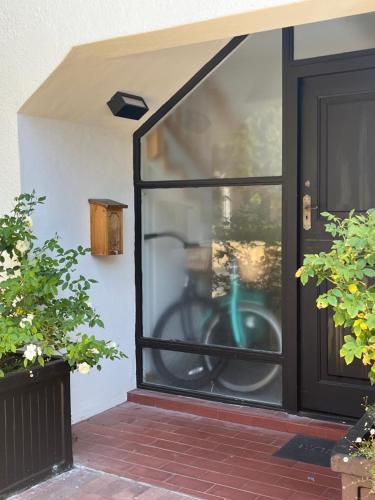 a glass door with a green bike in it at Lala Panzi - Grotto Beach, Voëlklip in Hermanus