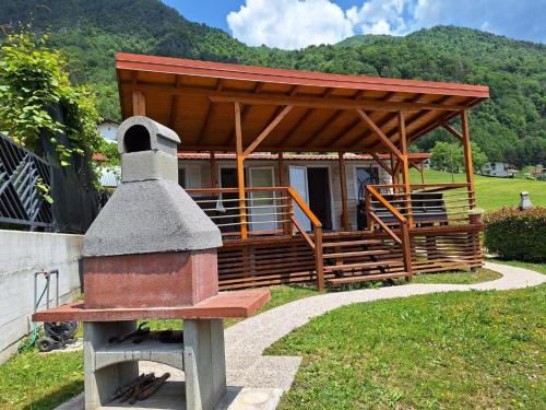 a wooden pavilion with a building with a roof at Holiday HOUSE NEAR THE SOČA RIVER in Tolmin