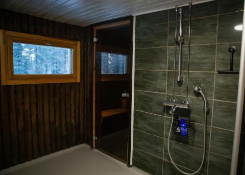ein Bad mit einer Dusche mit einem Schlauch in der Unterkunft Talo Mustikankukka Tervola, Finland in Tervola
