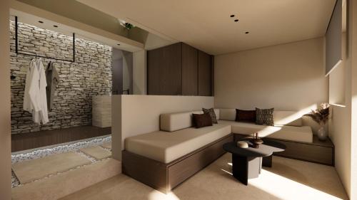 a living room with a couch and a stone wall at Agnadema Apartments in Firostefani