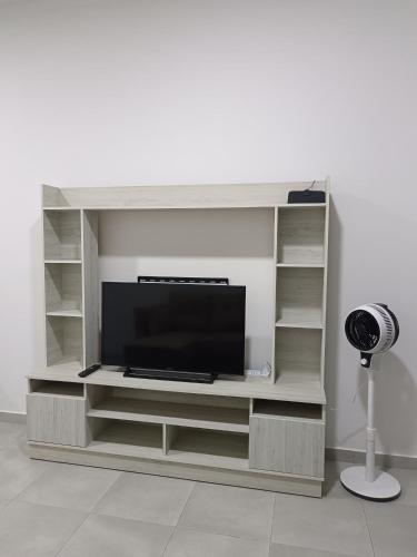 a entertainment center with a flat screen tv at Seaview Astana Sandakan in Sandakan