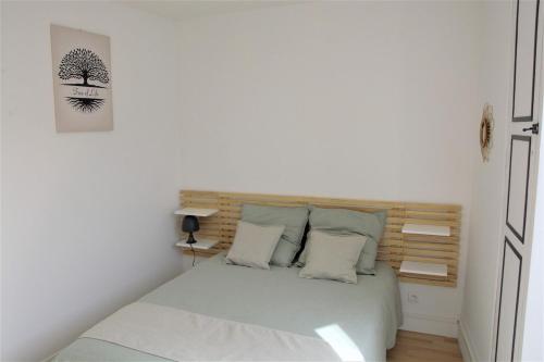 une chambre avec un lit avec une tête de lit en bois dans l'établissement Au coin de la rue, à Vatan