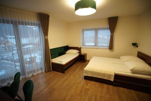 a bedroom with two beds and a large window at Willa Asia in Sromowce Niżne