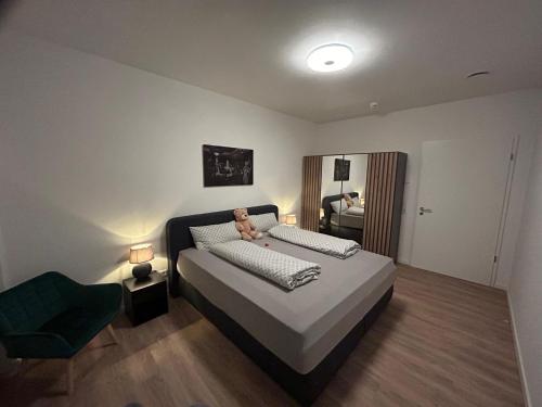 a bedroom with a bed with a teddy bear on it at Moderne Ferienwohnung Green Garden mit Garten und Stellplatz in Bremerhaven