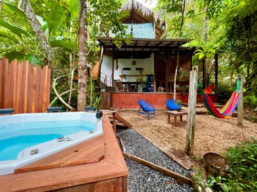 a backyard with a tub and a hammock and a house at Vila AMZ, Hostel Experiências in Alter do Chao