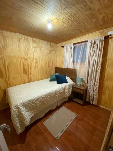 a small bedroom with a bed and a window at Hospedaje entre Volcanes y Araucarias in Curacautín