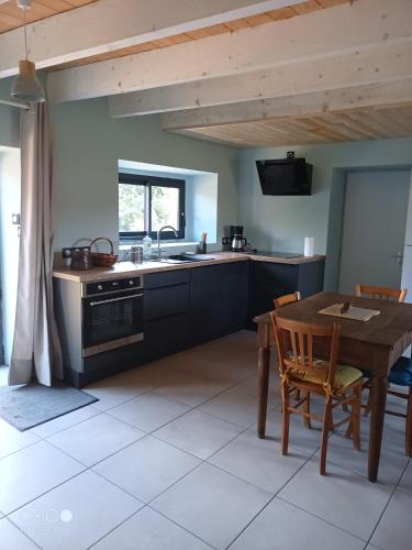 une cuisine avec une table en bois et une table et des chaises dans l'établissement La Garance voyageuse, à Villefranche-de-Rouergue