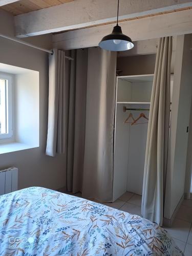 - une chambre avec un lit, une fenêtre et un placard dans l'établissement La Garance voyageuse, à Villefranche-de-Rouergue