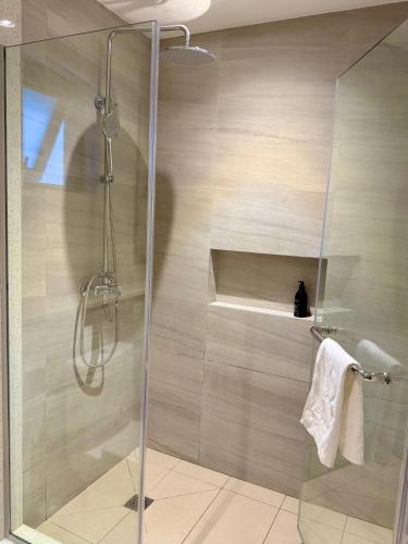 a shower with a glass door in a bathroom at Serenity Sunset View Apartment Hotel - Verdant Garden in Moka