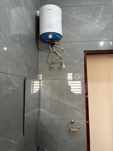 a bathroom with a blow dryer hanging on the wall at Yb home2 in Rāthdhana