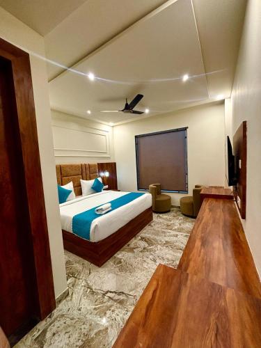 a hotel room with a bed and a flat screen tv at Hotel Majestic Heights Agra in Agra