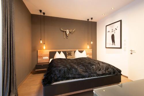a bedroom with a bed with a bull head on the wall at Hollywood Dream Penthouse & Apartments mit privater Sauna nahe Ischgl in Kappl