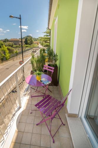 a balcony with two chairs and a purple table at B&B SMARTFIT HOUSE - Room & Relax in Pescara in Pescara