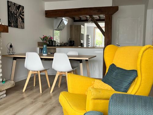 - un salon avec un canapé jaune et des fauteuils blancs dans l'établissement Maison chaleureuse avec jardin - Pause Normande, à Sées