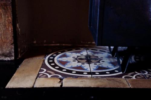 a clock sitting on the ground on a floor at Gîte Ferme de la Chevêche & Jacuzzi Namur in Sart-Saint-Laurent