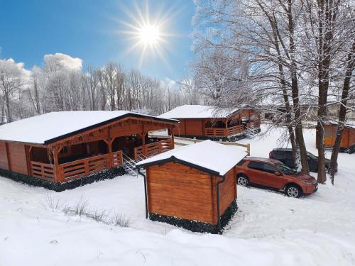 a cabin in the snow with a car parked in front at Sruby u potoka in Malá Morava