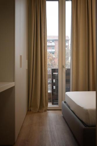 ミラノにあるMilan Luxury Suite - 15 Min Duomoのベッドと大きな窓のある寝室