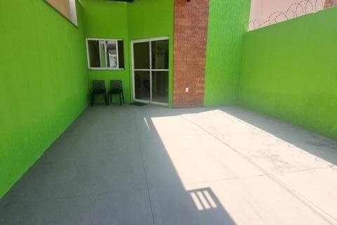 a green room with two chairs in front of a building at Casa Sophia9 in Três Lagoas