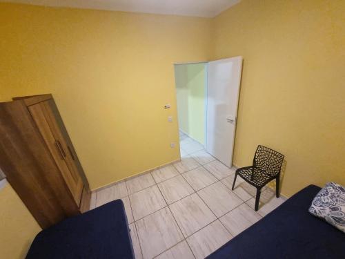 an empty room with a chair and a door at Casa Sophia9 in Três Lagoas