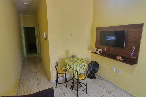 a room with a table with chairs and a television at Casa Sophia9 in Três Lagoas