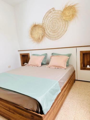 a bed with pink and blue pillows on it at Dar Taoufik in Djerba