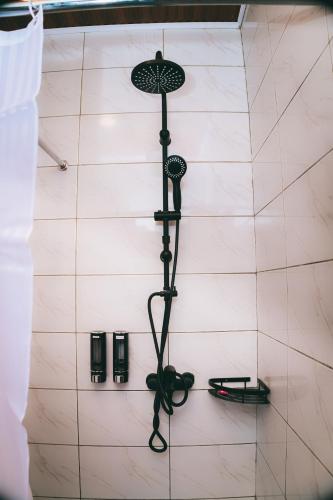 a shower in a white tiled bathroom at One Click Apartment in Kigali