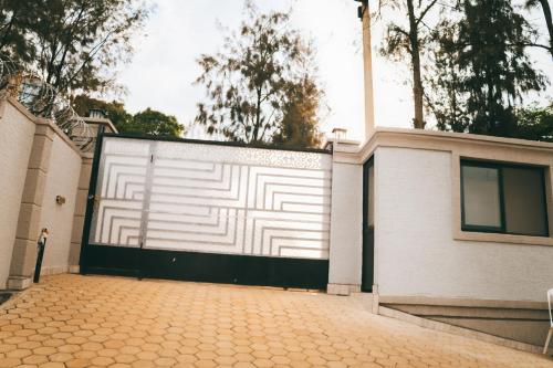 a white garage door with a black and white fence at One Click Apartment in Kigali