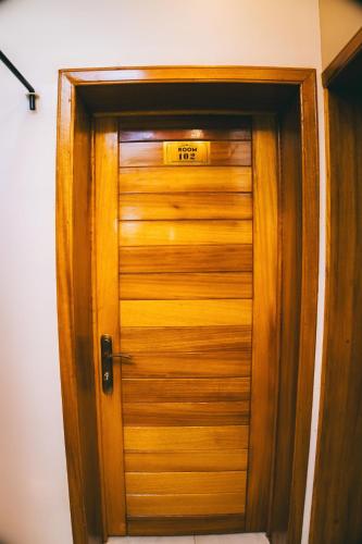 a wooden door with a sign on it at One Click Apartment in Kigali