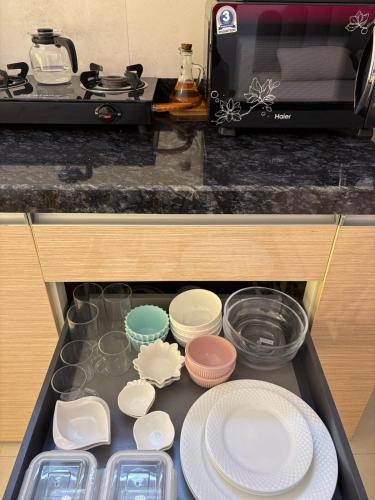 a drawer in a kitchen with plates and utensils at Elegant Escape , the complete home in Pune