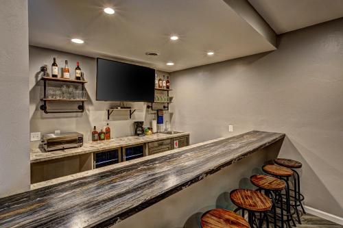 a bar with stools and a flat screen tv at Eagles Haven in Eagle River