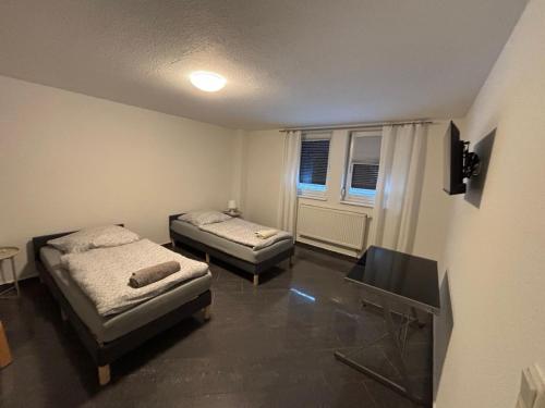 une chambre avec deux lits et une télévision dans l'établissement Ferienwohnung, Tageswohnung neben Braunschweig, à Meine