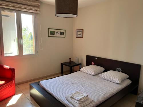 une chambre avec un lit et une chaise rouge dans l'établissement Charmante villa avec spa et panorama, à Lorgues