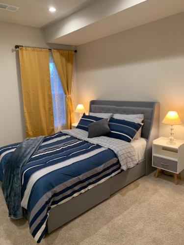 a bedroom with a bed with blue and white stripes at Private 2BR Apartment - Free Off Street Parking, Fast Wi-Fi & Laundry in Washington, D.C.