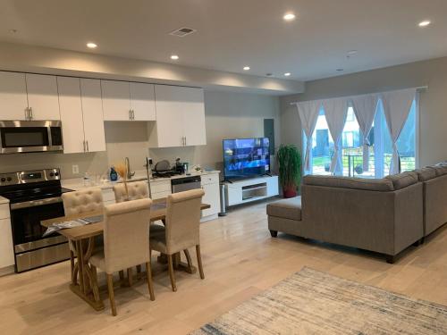 a kitchen and living room with a table and a couch at Private 2BR Apartment - Free Off Street Parking, Fast Wi-Fi & Laundry in Washington, D.C.