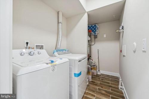 a small laundry room with a washer and dryer at Private 2BR Apartment - Free Off Street Parking, Fast Wi-Fi & Laundry in Washington, D.C.