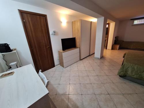 a living room with a television and a bedroom at Affittacamere Le Rondini 18 in Albiano