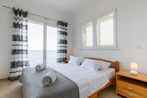 a bedroom with a bed and a large window at Holiday house Martinović in Prigradica