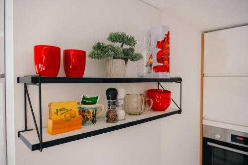 a shelf with pots and mugs on a wall at Apartman Fića, Ravna Planina in Pale