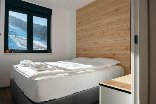 a bedroom with a large white bed with a window at Apartman Fića, Ravna Planina in Pale