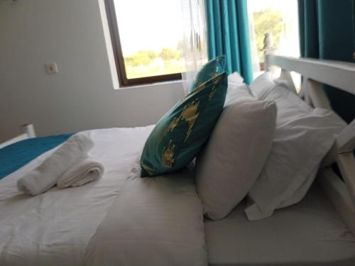 a bed with two pillows and a towel on it at Casa Marabella C2 in Ukunda
