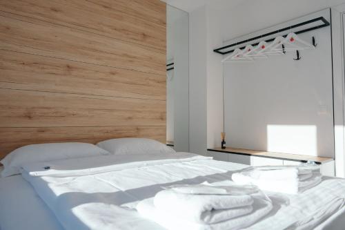 a bedroom with a white bed with a wooden headboard at Apartman Fića, Ravna Planina in Pale