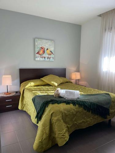 a bedroom with a bed with a yellow comforter at Casa da Avó Olinda in Góis