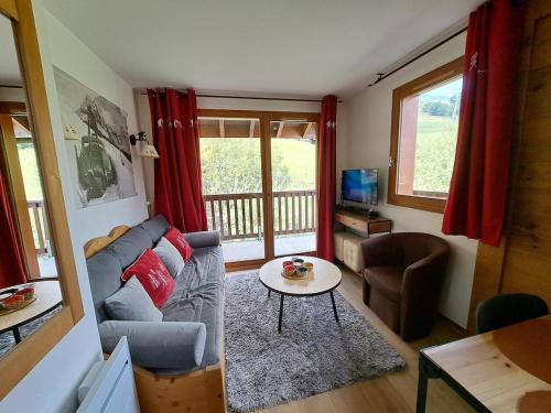 a living room with a couch and a table at Le Corbier, T3, 4-6 pers in Villarembert