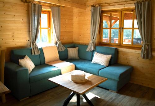 a living room with a blue couch and a table at Sruby u potoka in Malá Morava