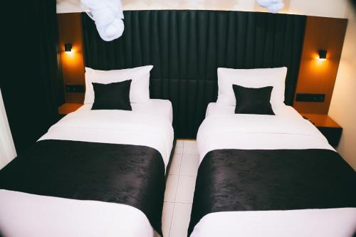 two beds in a room with black and white at One Click Apartment in Kigali